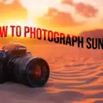 A DSLR camera placed on sandy ground against a vibrant sunset, with the text “How to Photograph Sunsets” floating above