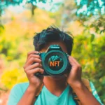 NFTs and photography concept with a photographer holding a camera featuring the NFT logo