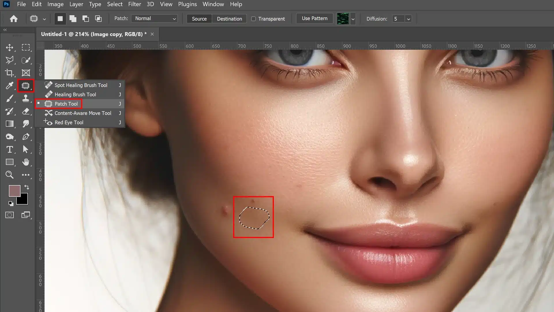 A photo showing a close-up of a woman's face. The Patch Tool is selected in the toolbar on the left, and a selection is made around an imperfection on the woman's cheek.