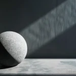 A textured stone sphere casting a shadow in a minimalist setting, illustrating the concept of adding shadows in Photoshop