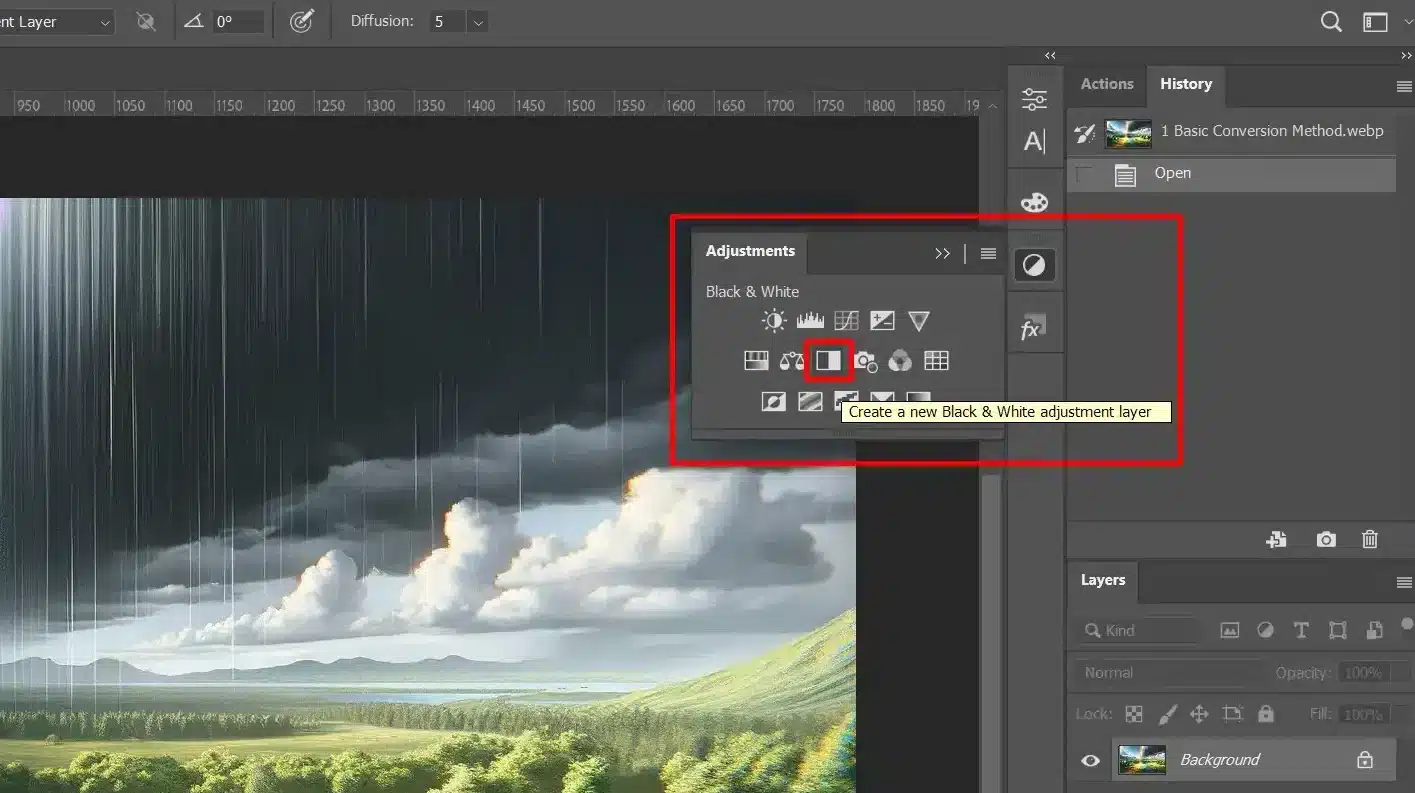 Screenshot of a photo editing interface showing a vibrant landscape with a rainbow and rain showing the first step of the conversion from color to a black and white.