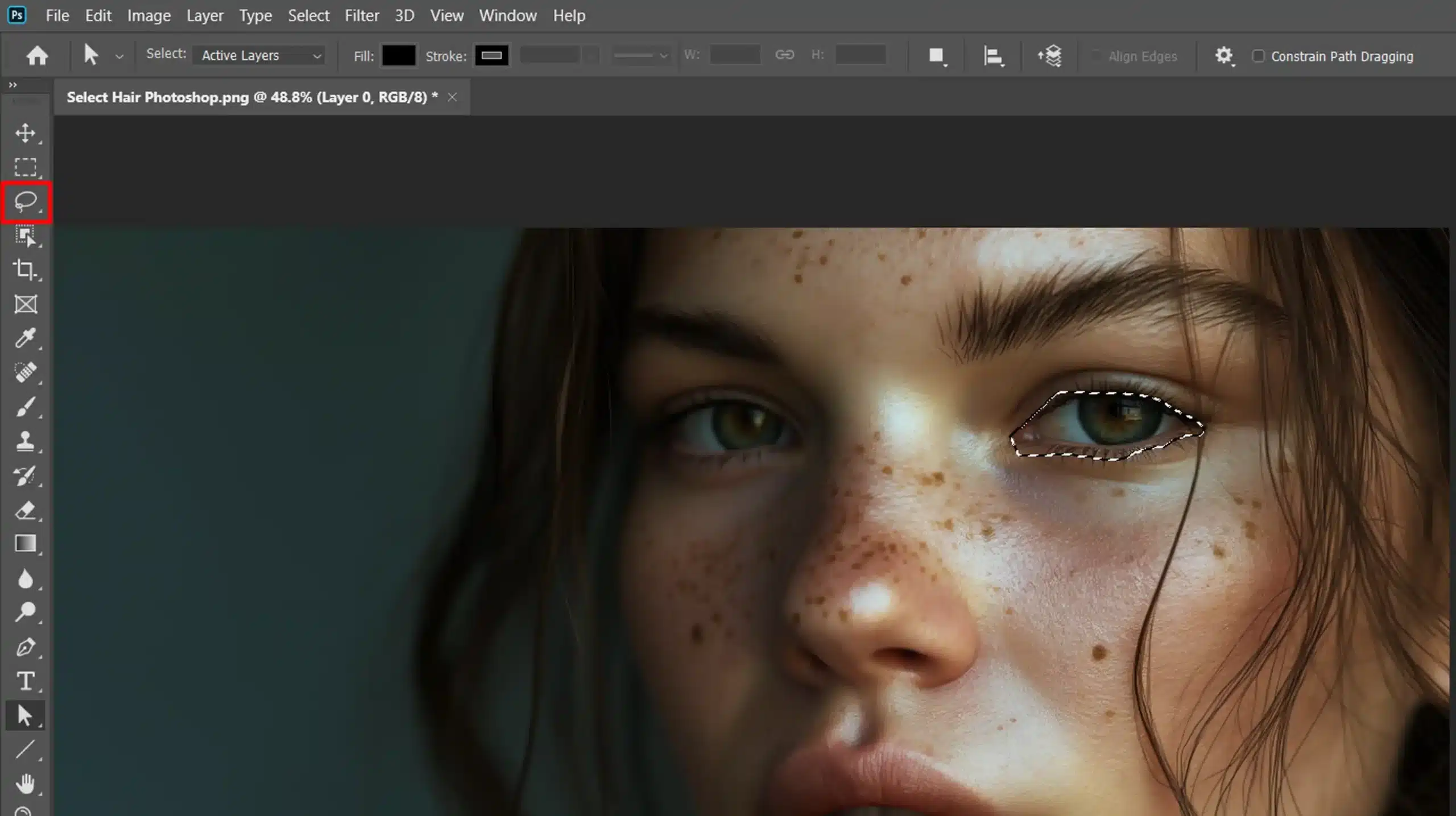 A close-up of a woman's face with the Lasso Tool selection visible around her eye in Photoshop