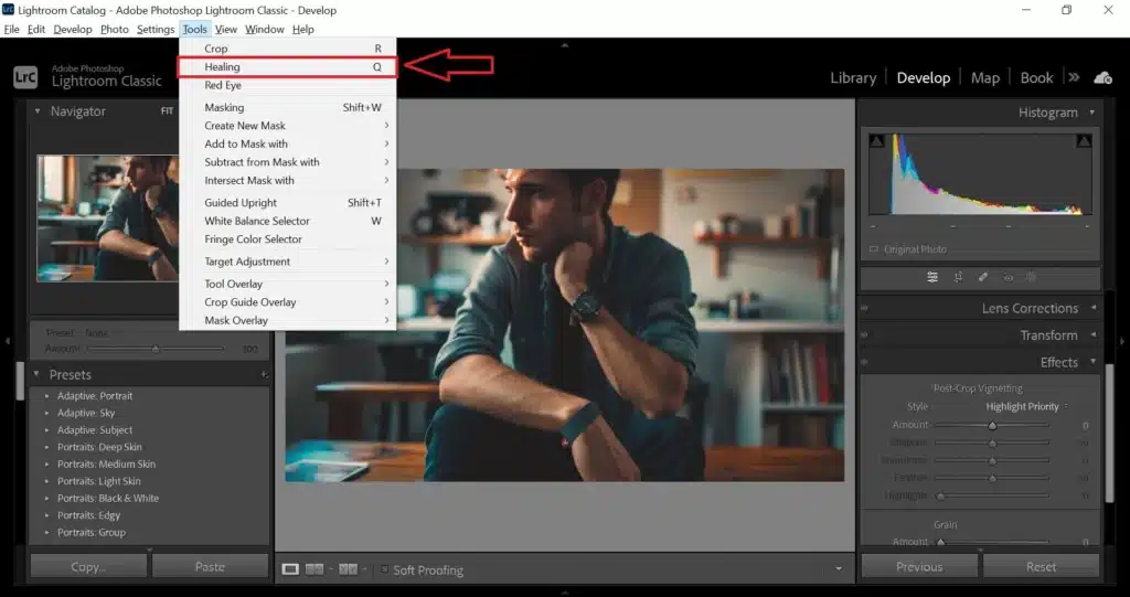 Screenshot of Adobe Lightroom interface with the 'Healing' tool highlighted under the 'Tools' menu. A photo of a man sitting thoughtfully is displayed in the main editing area. It is explaining the How to Use Healing Brush in Lightroom