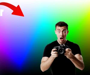 A surprised photographer holding a camera in front of a gradient background that showcases the vividness of 16-bit color depth. The image includes a color scale and a large red arrow pointing to the vibrant colors.